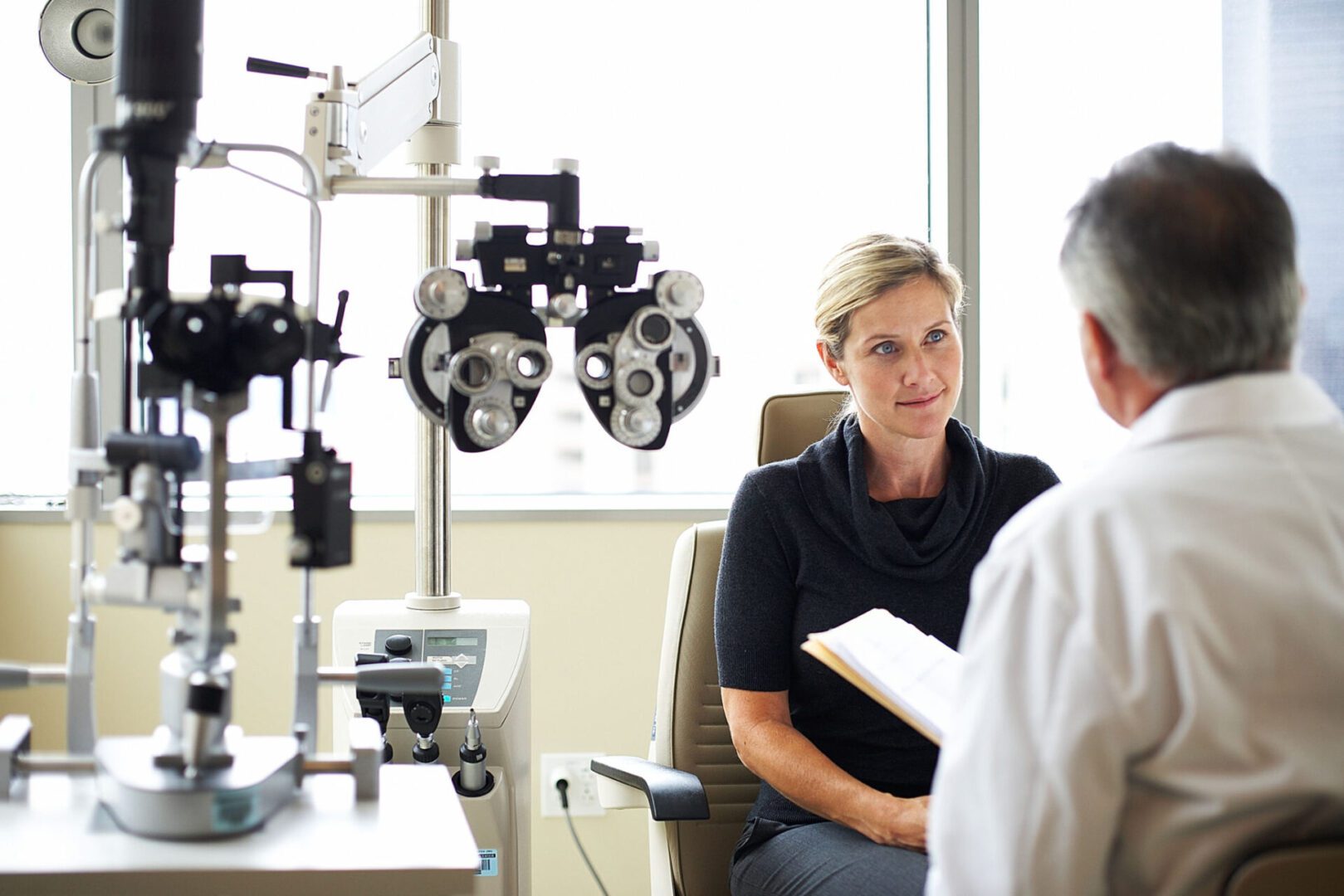 Eye exam consultation with optometrist and patient.